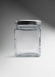 Frasco cuadrado de vidrio transparente con tapa de rosca plata premium para miel, especias y recuerdos 150 ml — imagen de producto