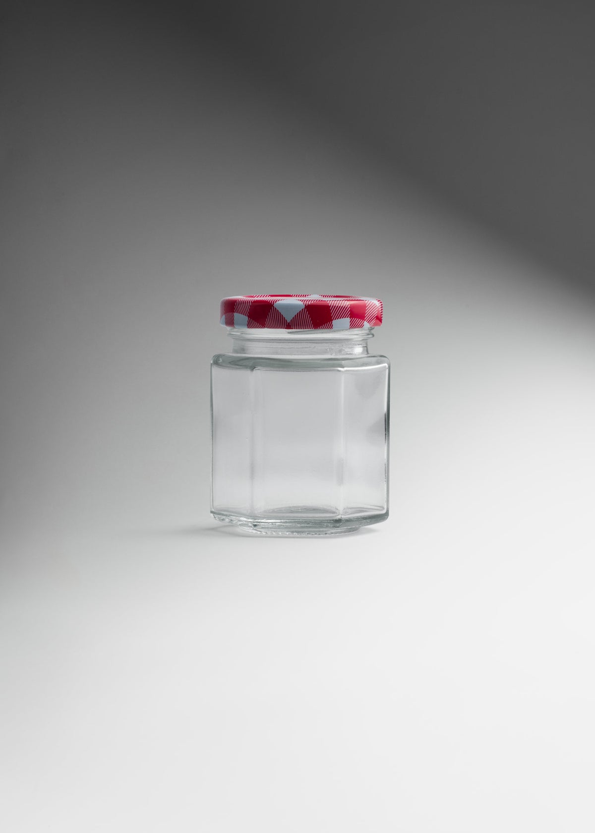 Frasco hexagonal de vidrio transparente con tapa roja uso alimenticio 85 ml — imagen de producto