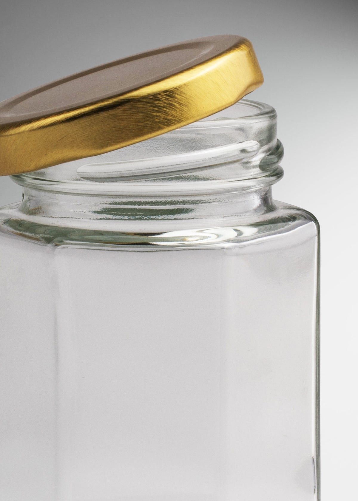 Frascos hexagonales de vidrio transparente con tapa dorada uso alimenticio de 45 a 500 ml — imagen de producto