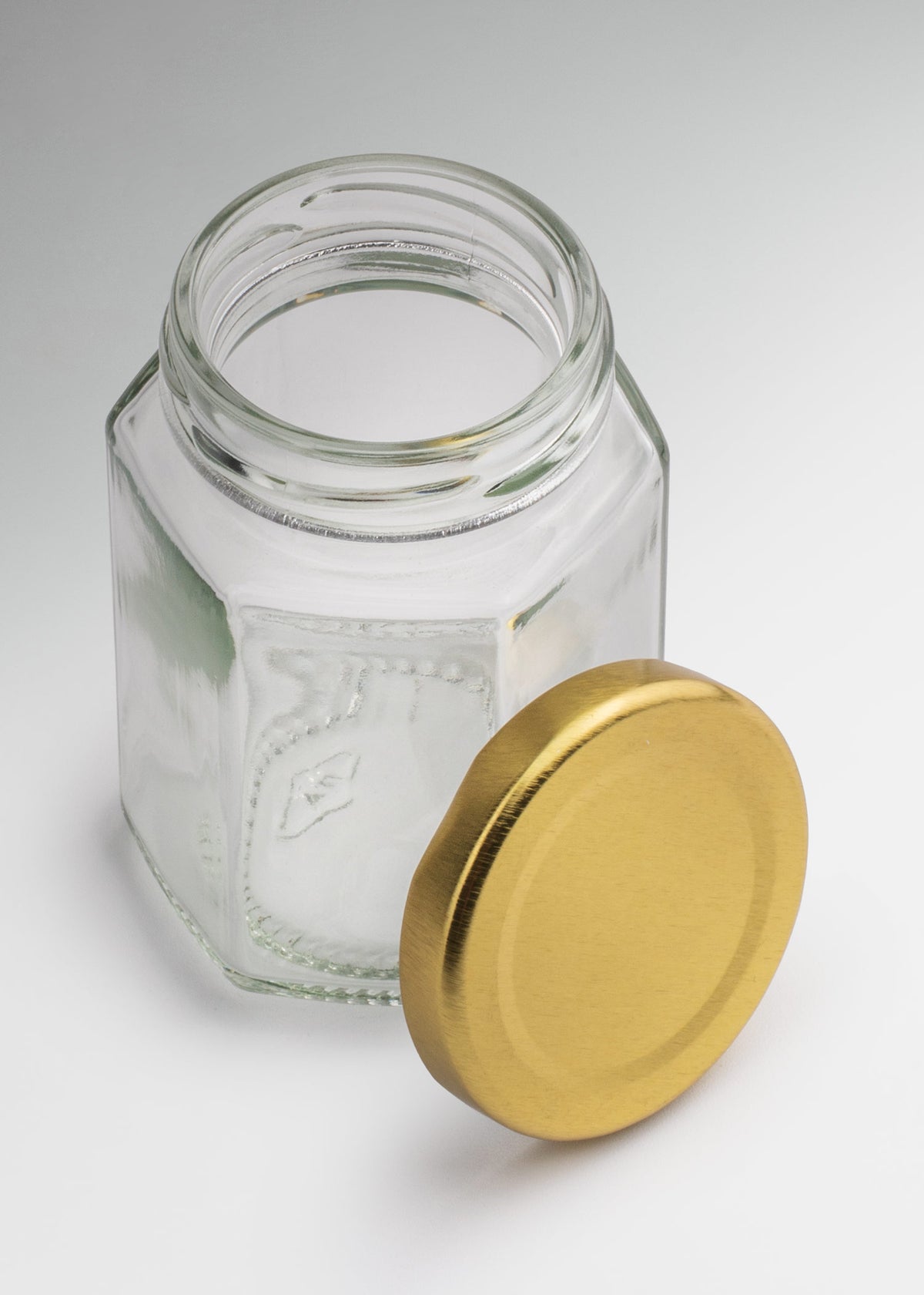 Frascos hexagonales de vidrio transparente con tapa dorada uso alimenticio de 45 a 500 ml — imagen de producto