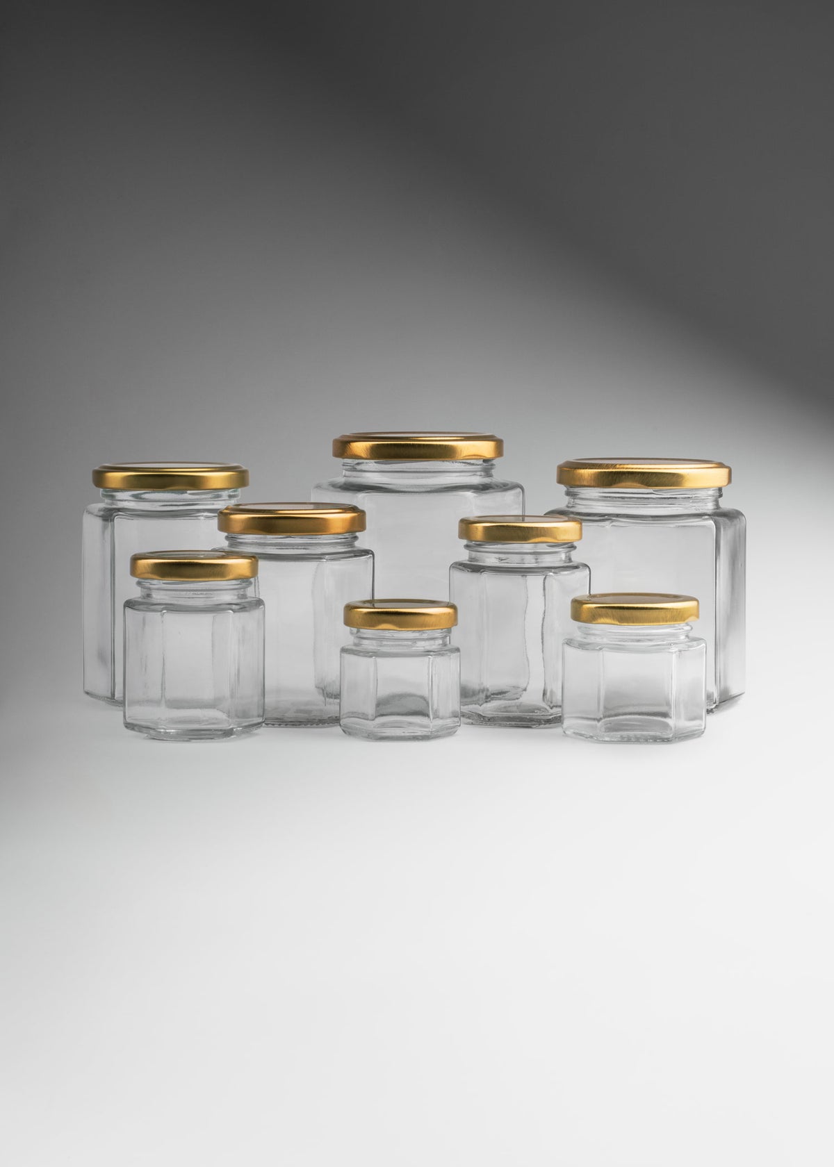Frascos hexagonales de vidrio transparente con tapa dorada uso alimenticio de 45 a 500 ml — imagen de producto