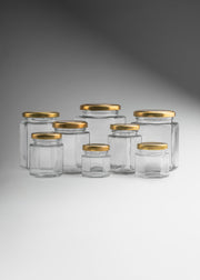 Frascos hexagonales de vidrio transparente con tapa dorada uso alimenticio de 45 a 500 ml — imagen de producto