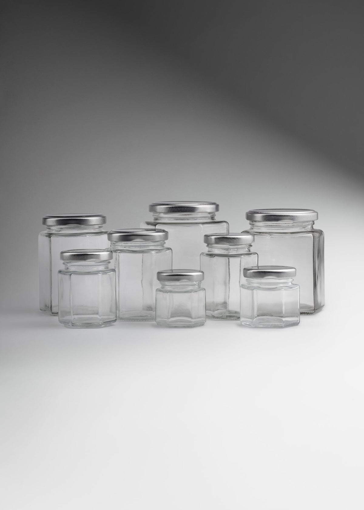 Frascos hexagonales de vidrio transparente con tapa plateada uso alimenticio de 45 a 500 ml — imagen de producto
