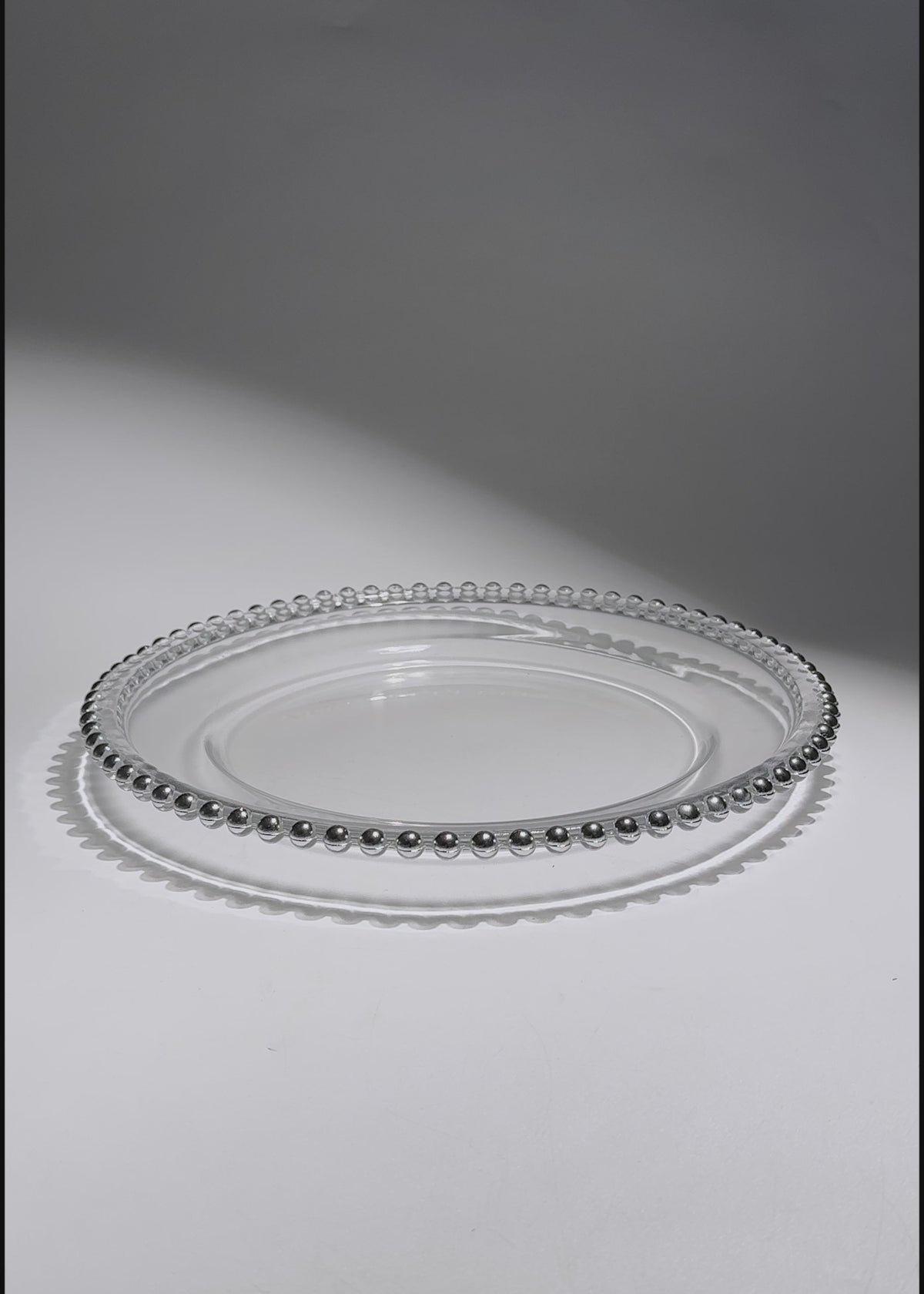 Cargar vídeo: Video de Plato base de vidrio transparente con filo plata Perla Ø 21 cm para banquetes, hoteles, restaurantes, bodas y eventos