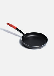 Sartén antiadherente de aluminio negro con mango de acero y funda de silicón para cocción y preparación de alimentos. Largo 52.8 cm (21"), alto 4.5 cm (2"), Ø 28 cm (11") — imagen de producto